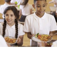 Over shoulder view of kids being served in school cafeteria