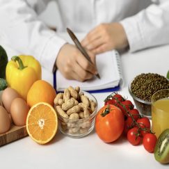 Young female nutritionist with healthy food writing diet plan in office, closeup