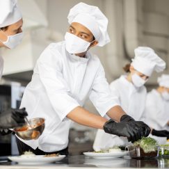 Multiracial,Group,Of,Cooks,Finishing,Main,Courses,While,Working,Together